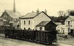 Carte postale figurant une ancienne gare et sa ligne traversée par un train.