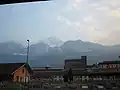 La gare d'Aoste, les bâtiments de l'industrie sidérurgique Cogne et, à l'arrière-plan, le pic de Nona et le mont Émilius.