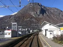 Vue des voies, quais et bâtiments de la gare.