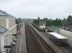L'intérieur de la gare vu de la passerelle, avec le bâtiment voyageurs, les deux voies et les deux quais