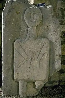Stèle celtique figurant un personnage portant une chandelle.