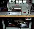 Machine industrielle moderne, conçue pour un travail intensif. La machine est mécanique et le moteur (puissant) est placé sous la table