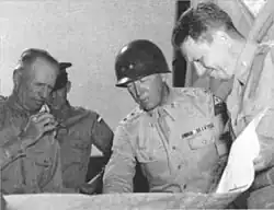 Photo noir et blanc de McNair qui s'entretient avec George Patton et d'autres au Desert Training Center.