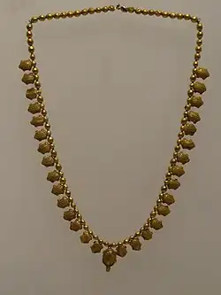 Photographe d'un collier composé de miniatures de tortue en or.