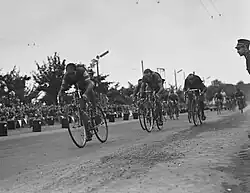Photographie en noir et blanc montrant plusieurs cyclistes en course.