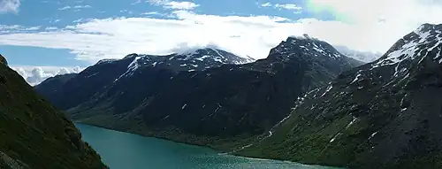 Plusieurs vallées en altitude perpendiculaires à une grande vallée principale avec un lac aux eaux turquoise en son sein.