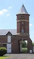 Tour pigeonnier avec porche et horloge.