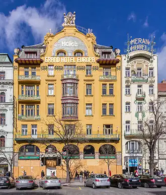 La façade sur rue d'un bâtiment art nouveau, à dominante jaune, à cinq étages.