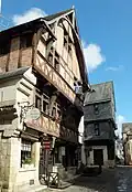 Grand carroi (carrefour) avec la maison rouge et la maison bleue d'un commerçant plus aisé.