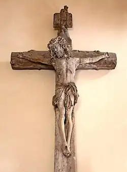 Photographie d'un Christ en croix suspendu à un mur.