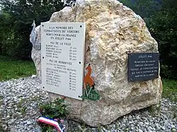 Rocher calcaire massif avec deux plaques commémoratives à la mémoire des combattants du Vercors morts en juillet 1944 et une liste de 12 noms