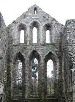 Photographie d'un chevet d'église intact, mais sans verrières ni voûtes ni charpente