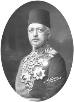 Portrait d'un homme barbu portant un fez et un costume diplomatique.