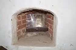 Une meurtrière à hauteur d'homme s'ouvrant vers l'extérieur.
