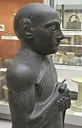 Statue V, détail : haut du corps avec épaule et bras visibles, tête recollée. British Museum.