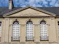 Détail de l'avant-corps avec ses fenêtres à impostes arrondies en demi-cercle.