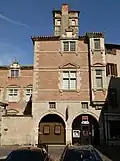 Photo couleur d'une maison Renaissance à arcades ouvertes sur la rue au rez-de-chaussée.