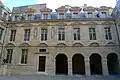 À droite, l'aile comporte quatre arcades, jadis à usage de remises à carrosses.
