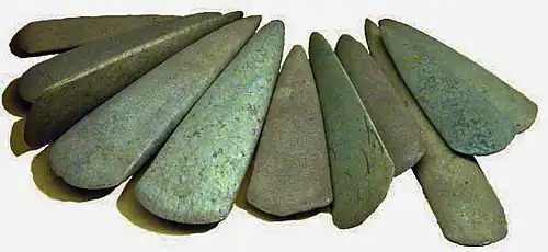 Haches polies découvertes dans le dépôt de Bernon (Arzon, Morbihan).Ces pièces de grande dimension (15 à 28 cm) datent du Ve millénaire av. J.-C. Certaines sont en fibrolite locale, d'autres sont en roches vertes alpines et ont probablement été obtenues par échange.