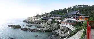 Photographie d'un temple surplombant la mer sur des rochers.