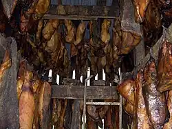 Hákarl séchant à des poutres en bois.
