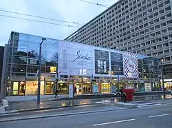 Photographie des Halles de Bocuse (rénovation des Halles) avec en fond l'un des bâtiments d'habitation de l'architecte Zumbrunnen.