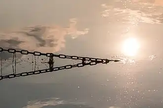 Une chaîne plonge en soirée dans le lac de barrage Halterner Stausee.