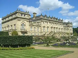 Vaste jardin à la française, surmonté de la large terrasse d'un vaste bâtiment au toit orné d'une balustrade de pierre