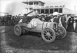 Photo d'ensemble de Henri Cissac prenant la pose au volant.