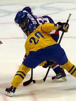 Photographie couleur de Demitra en bleu face à Sedin en jaune