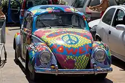 Photographie d'une coccinelle peinte aux couleurs du Flower Power.
