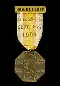 Médaille octogonale sur fond noir avec un ruban coloré