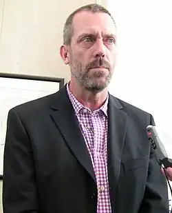 Hugh Laurie jouant de la guitare à un concert.
