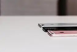 Trois iPhone posés sur une table.