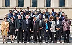 Photo d'un groupe d'hommes et de femmes en costume, alignés debout les uns à côté des autres