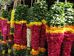 Malai (colliers de fleurs) suspendus dans un stand de fleuriste au marché.