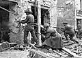 Un soldat canadien fait feu sur l'ennemi dans une maison à Caen, 10 juillet 1944.
