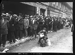 File d'attente d'hommes le long d'un trottoir.