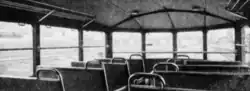 Photographie en noir et blanc montrant les sièges et la vue panoramique depuis l'intérieur de l'autorail.