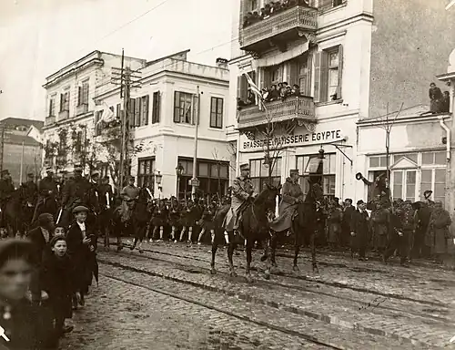 photographie sépia : des troupes à cheval dans une rue