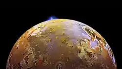Une moitié de la lune est représentée, celle-ci apparaissant orangée voire marron. Une éjection brillante blanche est observable à la surface.