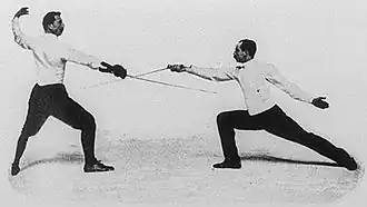 Photo de deux hommes pendant un combat d'escrime.
