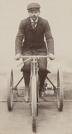 Photo de Marcellin prenant la pause au guidon de son tricycle Phébus.