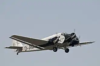 Photographie d'un avion à hélices dans les airs.
