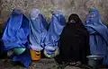 Burqas et niqab portés par une tribu pachtoune devant un centre de distribution alimentaire en Iran (2011).