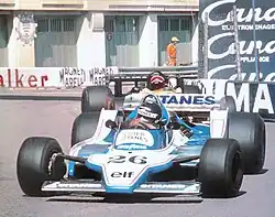 Photo de l'avant d'une monoplace blanche et bleue sur un circuit urbain.