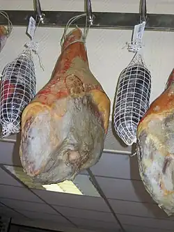 Jambons et noix de jambon après affinage, suspendus, prêts à entrer en commercialisation