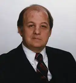Portrait photographique d'un homme à la calvitie avancée.