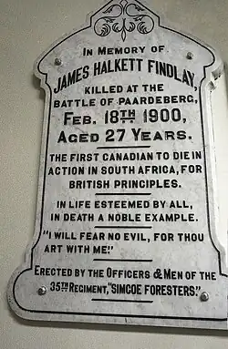 Plaque en pierre blanche portant l'inscription « In memory of James Halkett Findlay killed at the battle of Paardeberg, Feb. 18th 1900, aged 27 years. The first Canadian to die in action in South Africa, for British principles. In life esteemed by all, in death a noble example. "I will fear no evil, for thou art with me." Erected by the Officers and Men of the 35th Regiment, "Simcoe Foresters." »