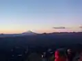 Photo couleur d'un lever de soleil du haut d'une montagne.